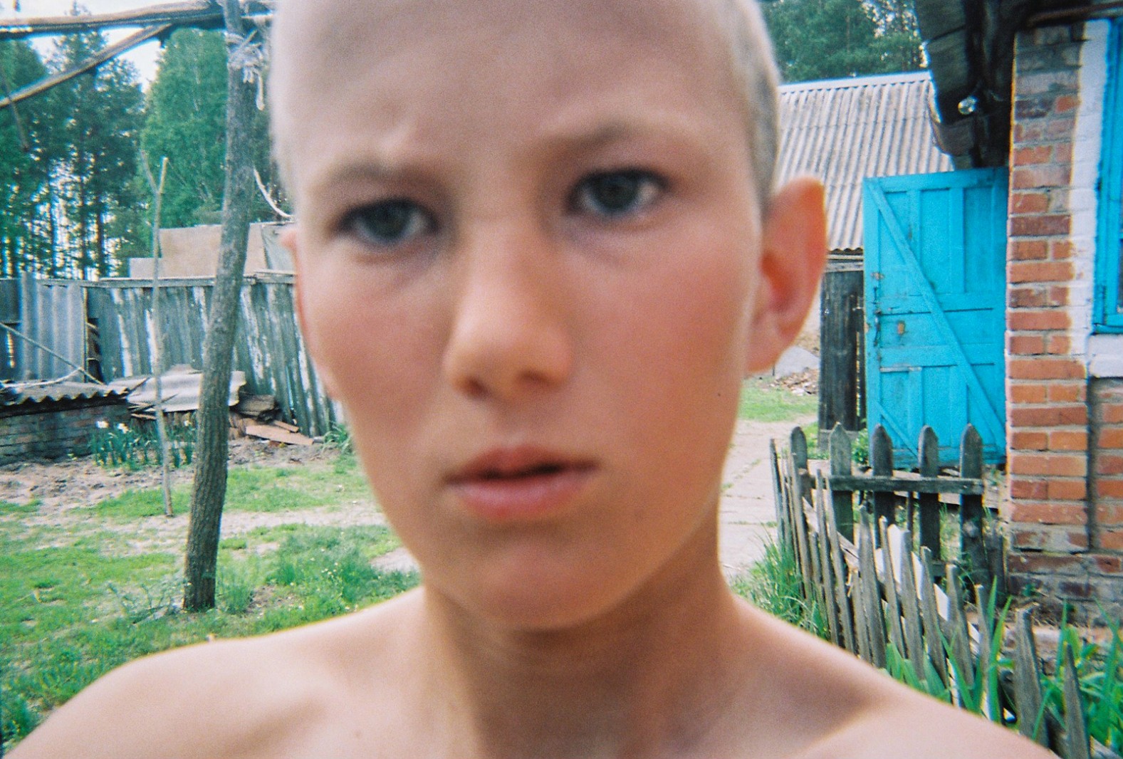 A young boy takes a 'selfie' in outside his house near Chernobyl