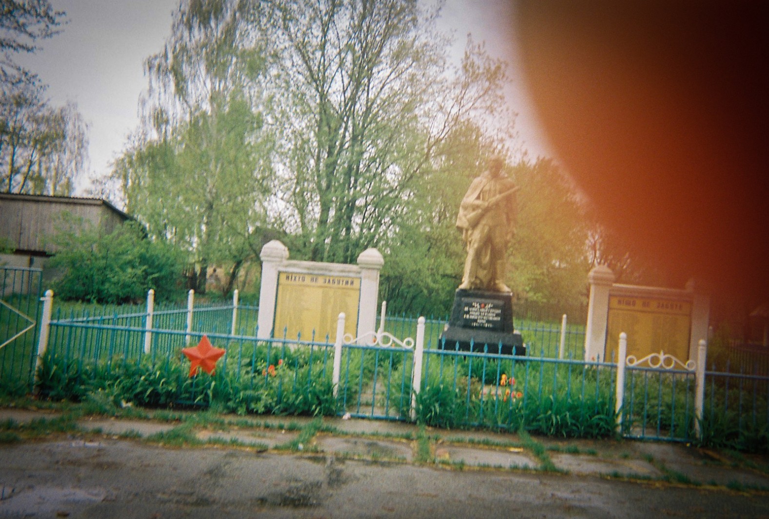 A snapshot of a memorial to the Great Patriotic War in a village near the Chernobyl Exclusion Zone. The finger over the lens belongs to a woman who lives in the village.