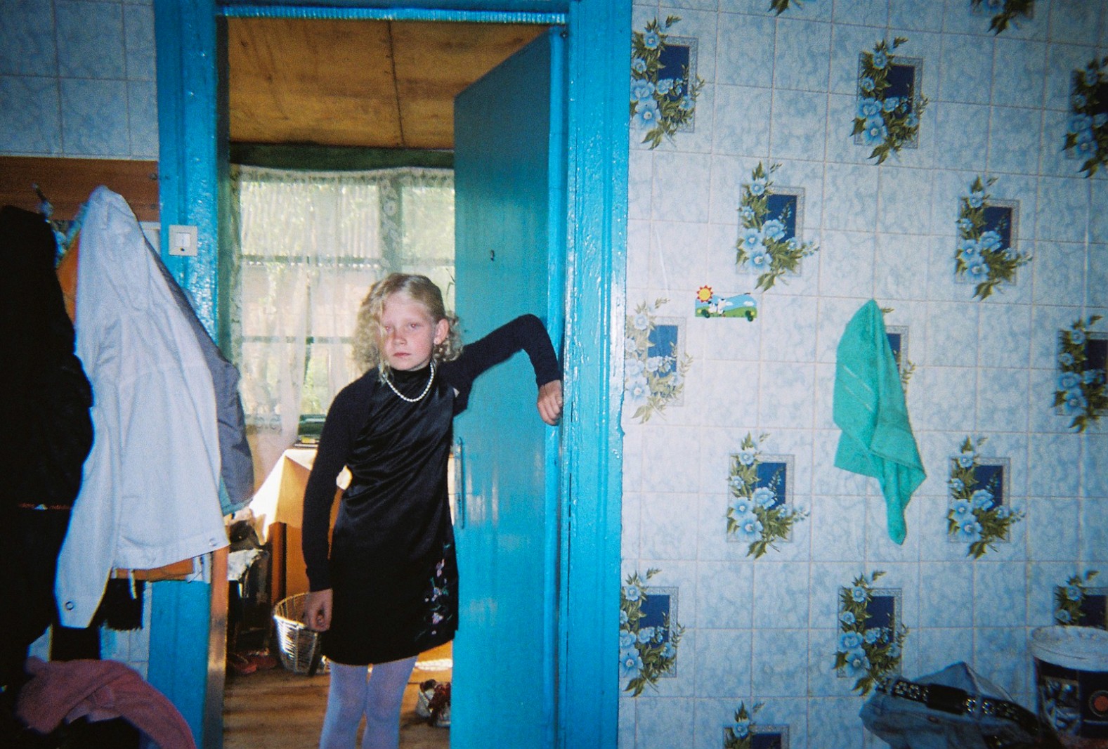 A young girl poses for the camera in her house adjacent to the Chernobyl Exclusion Zone