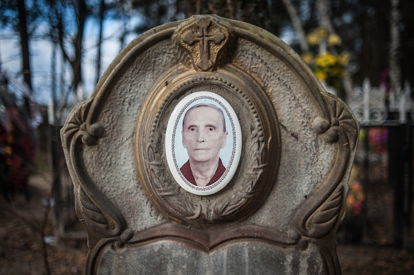 A tombstone with a photograph of the deceased in a cemetery near Chernobyl