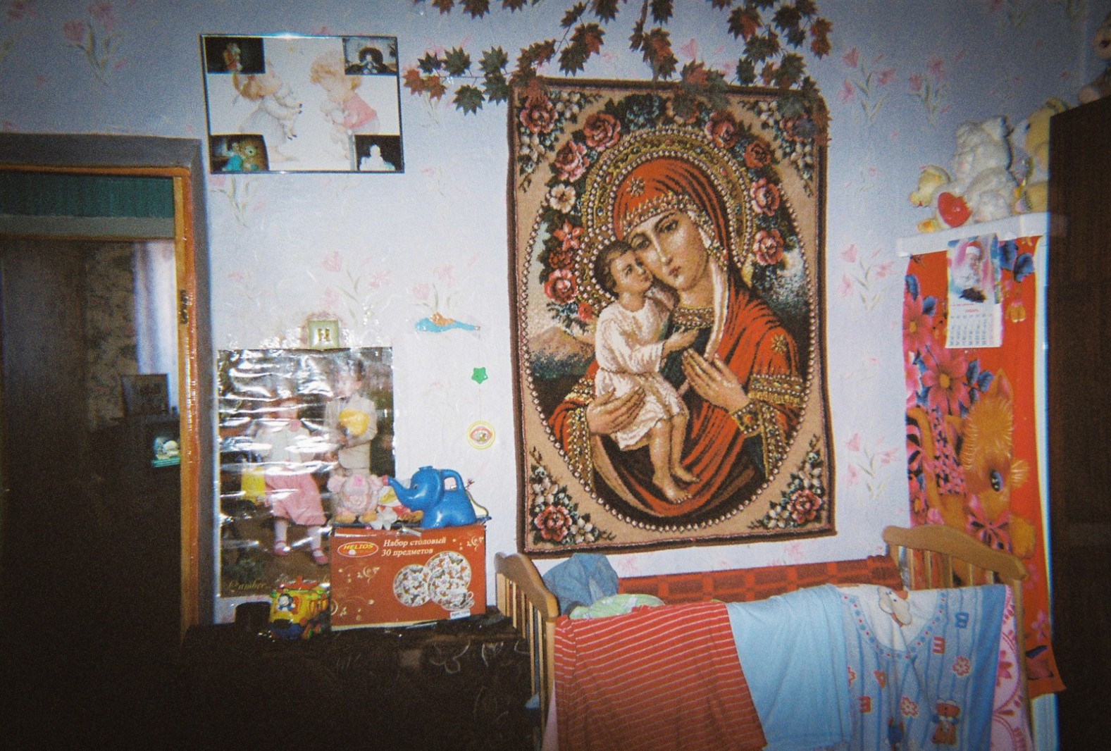 A catholic tapestry is stuck to the wall in a child's bedroom